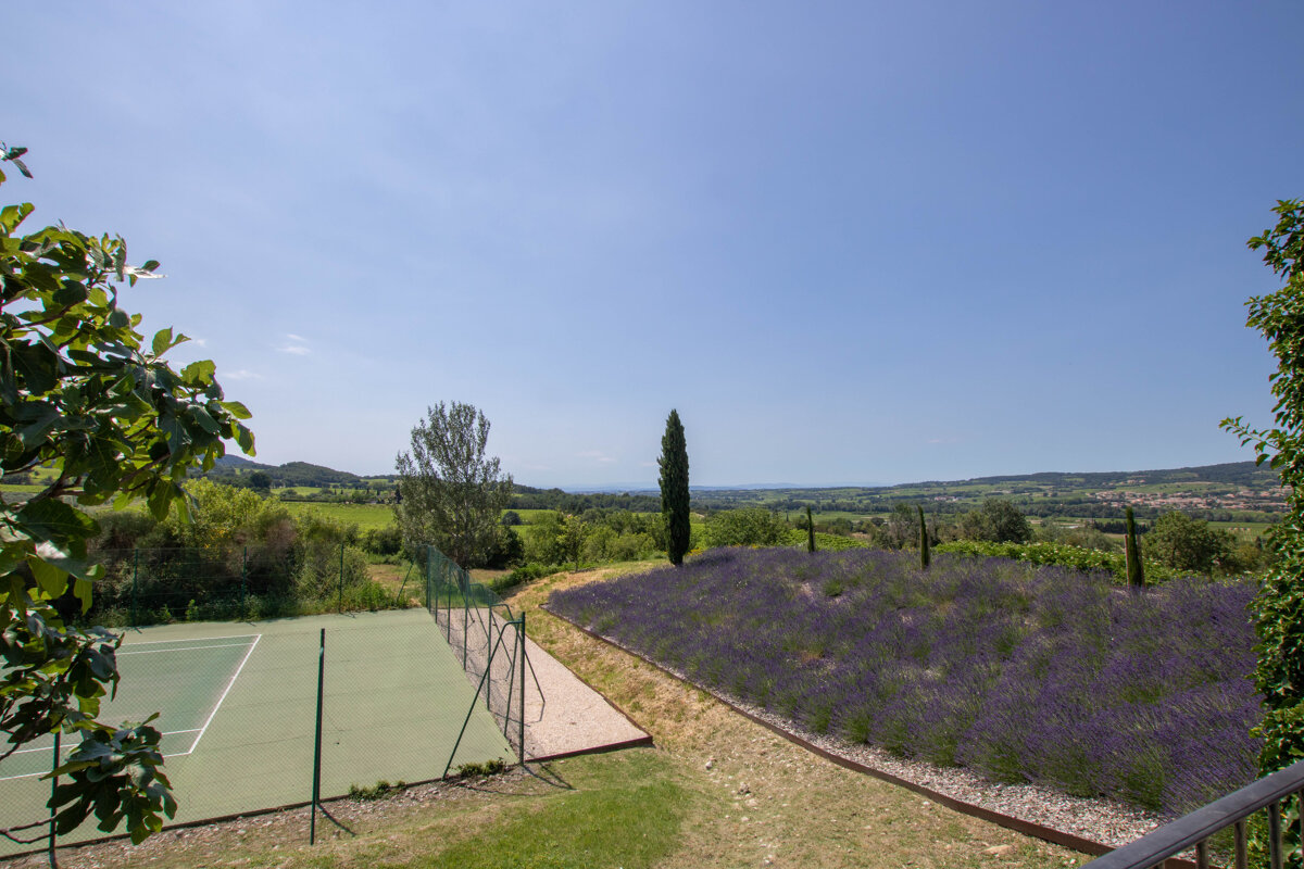 A tennis court with a view of a lavender field