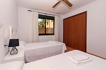 A bedroom with two beds and a ceiling fan