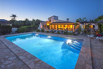 A house with a large swimming pool in front of it