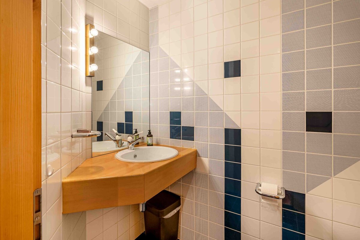 A bathroom with blue and white tiles and a sink