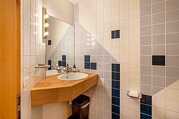 A bathroom with blue and white tiles and a sink