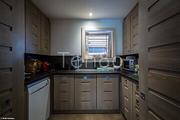 A kitchen with wooden cabinets and appliances and the word terlon on the bottom