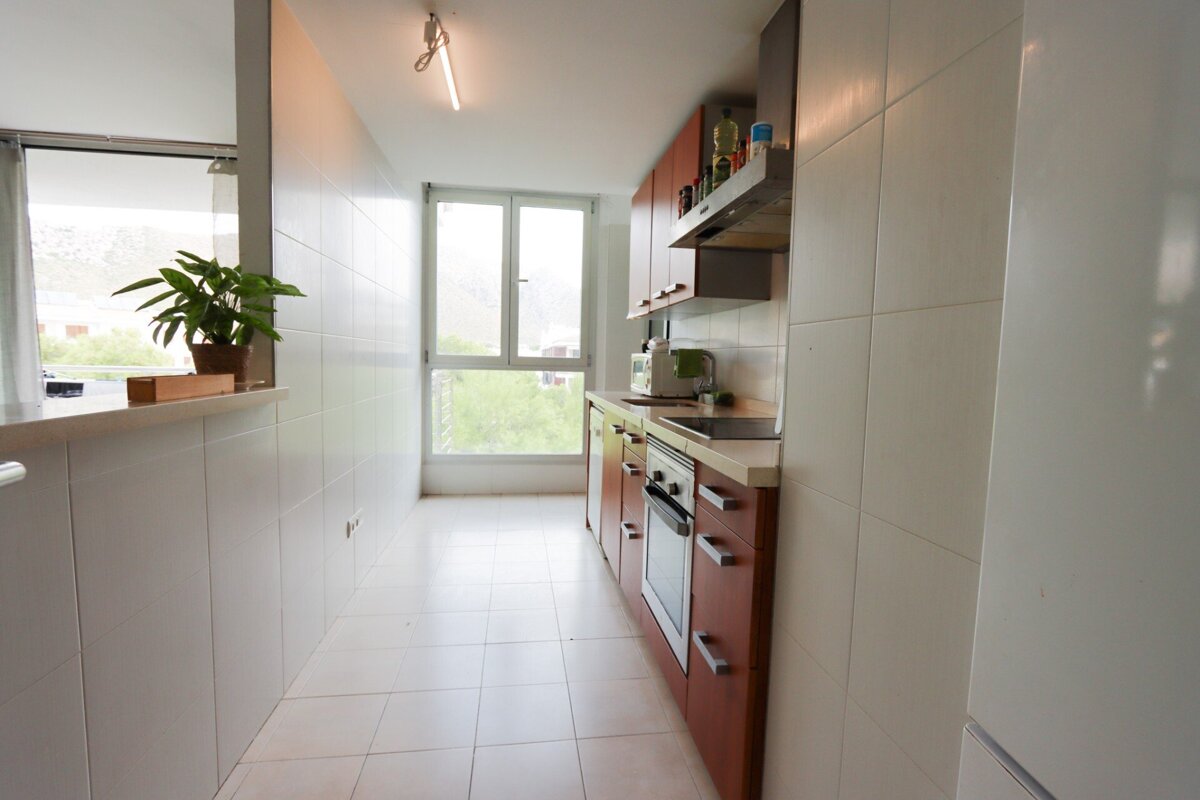 A kitchen with brown cabinets and white tile floors