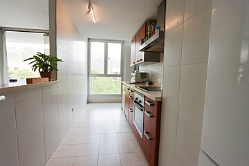 A kitchen with brown cabinets and white tile floors