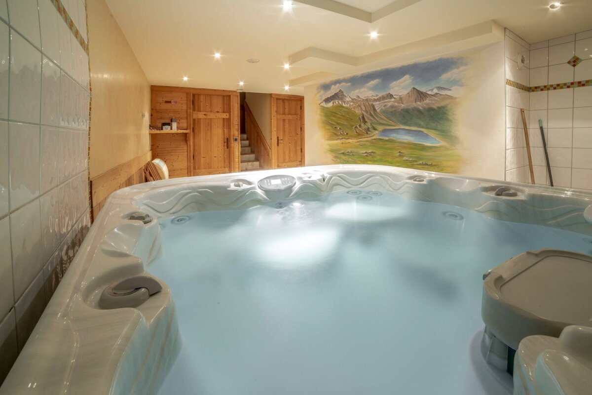 A hot tub with a painting of mountains on the wall behind it