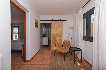 A hallway with a sliding barn door and a chair