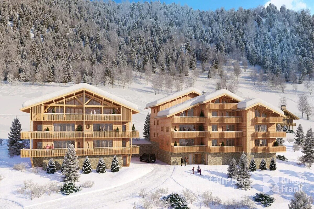 Two grand wooden chalets with balconies sit amidst a snow-covered mountain and pine forest. A beautiful winter wonderland scene.