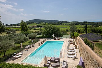 A large swimming pool surrounded by chairs and umbrellas with the word immobilier on the bottom