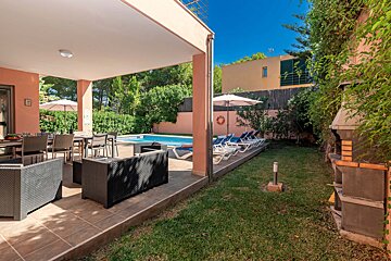 A patio with chairs and umbrellas next to a pool