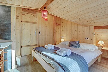A wooden bedroom with a bed and a sink