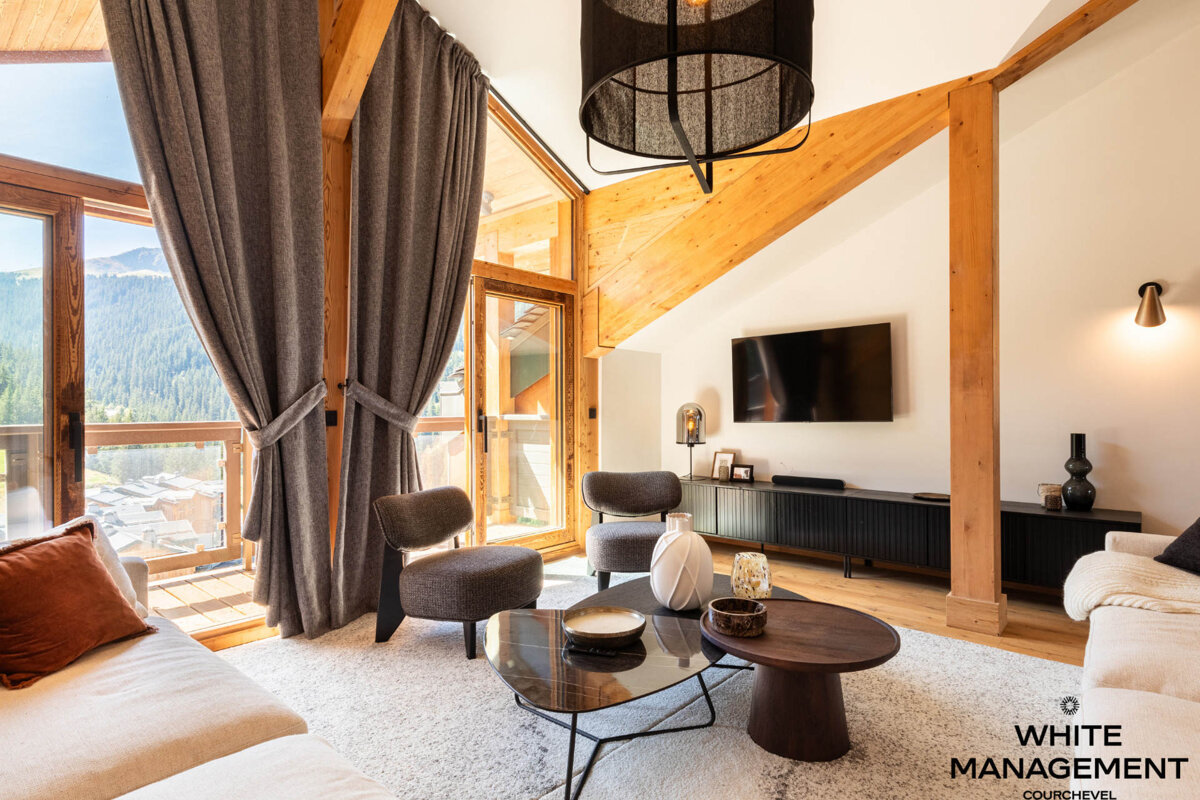 A living room with a couch and chairs and a flat screen tv