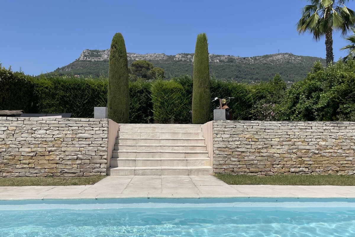 Stairs leading up to a swimming pool with mountains in the background