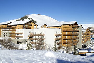 A snowy building with a mountain in the background