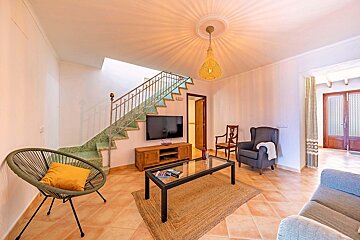 A living room with a staircase and a flat screen tv