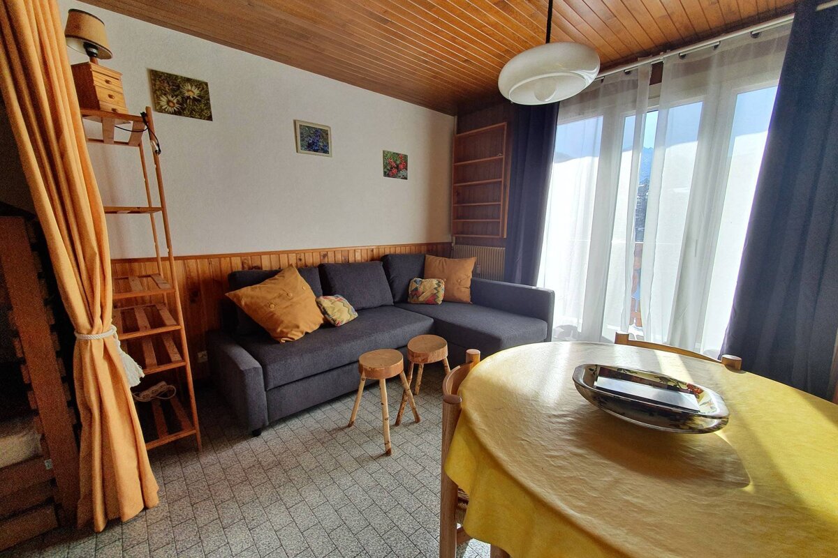 A living room with a couch and a yellow table cloth