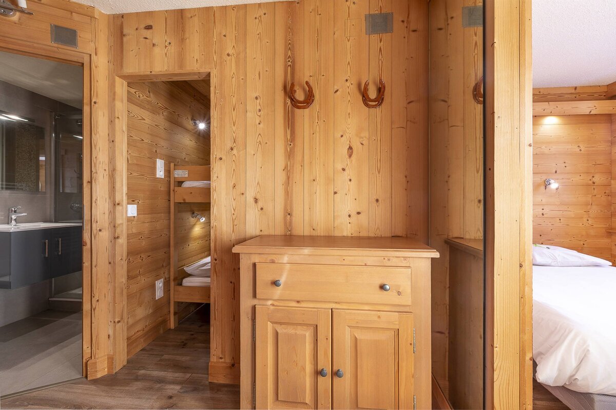 A bedroom with a bunk bed and a dresser