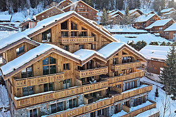 A large wooden building with snow on the roof