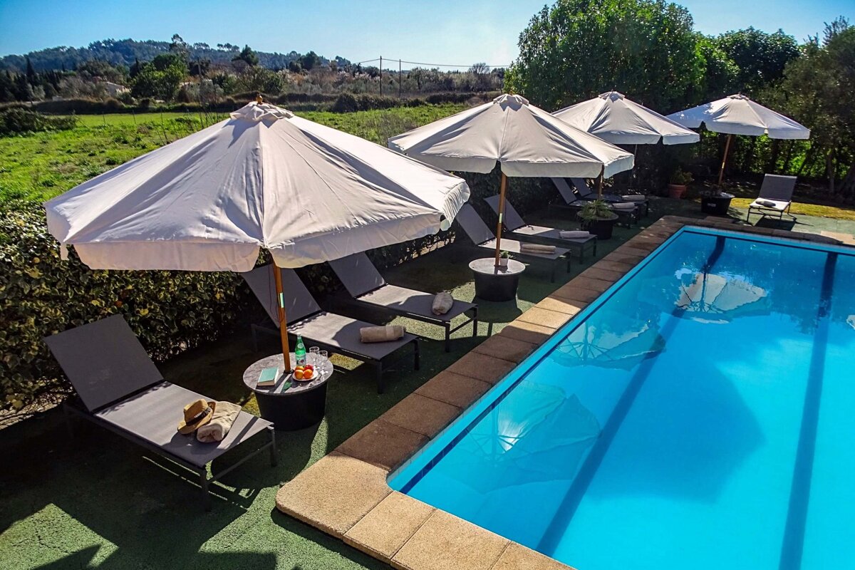 A swimming pool with chairs and umbrellas around it