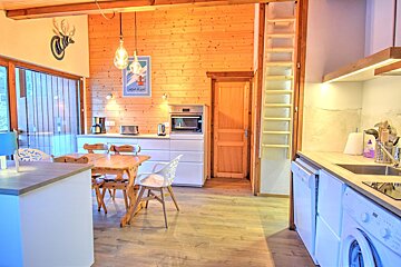 A kitchen with a table and chairs and a poster on the wall that says