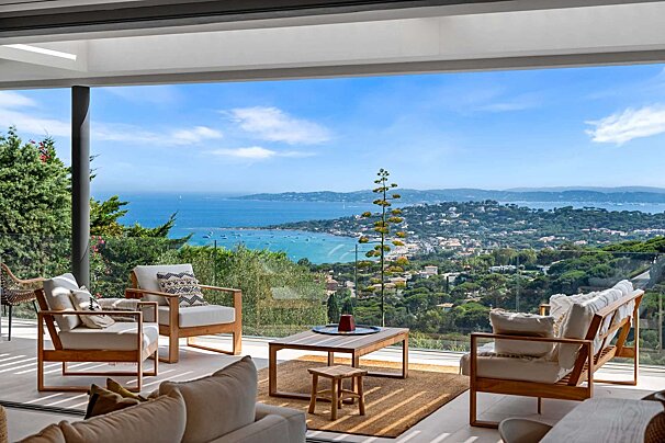 A living room with a view of the ocean and mountains