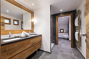 A bathroom with two sinks and a toilet