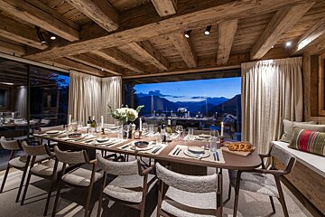 A dining room with a large table and chairs