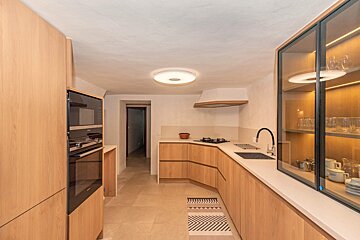 A kitchen with wooden cabinets and white counter tops
