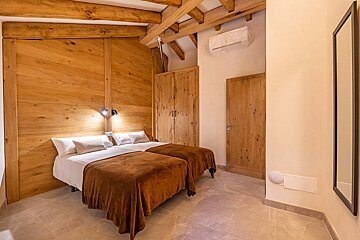 A bedroom with two beds and a mirror