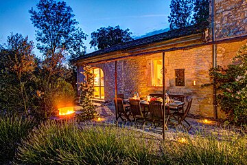 A patio with a table and chairs and a fire pit