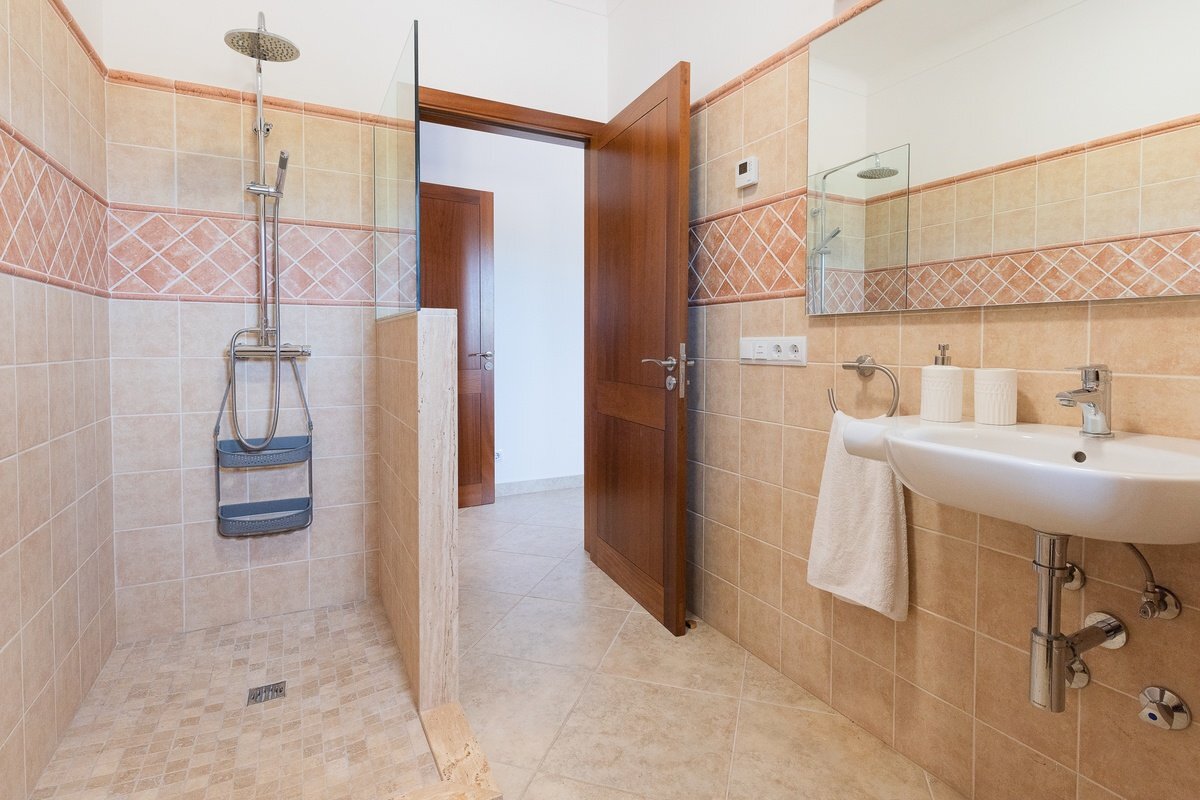 A bathroom with a walk in shower and a sink