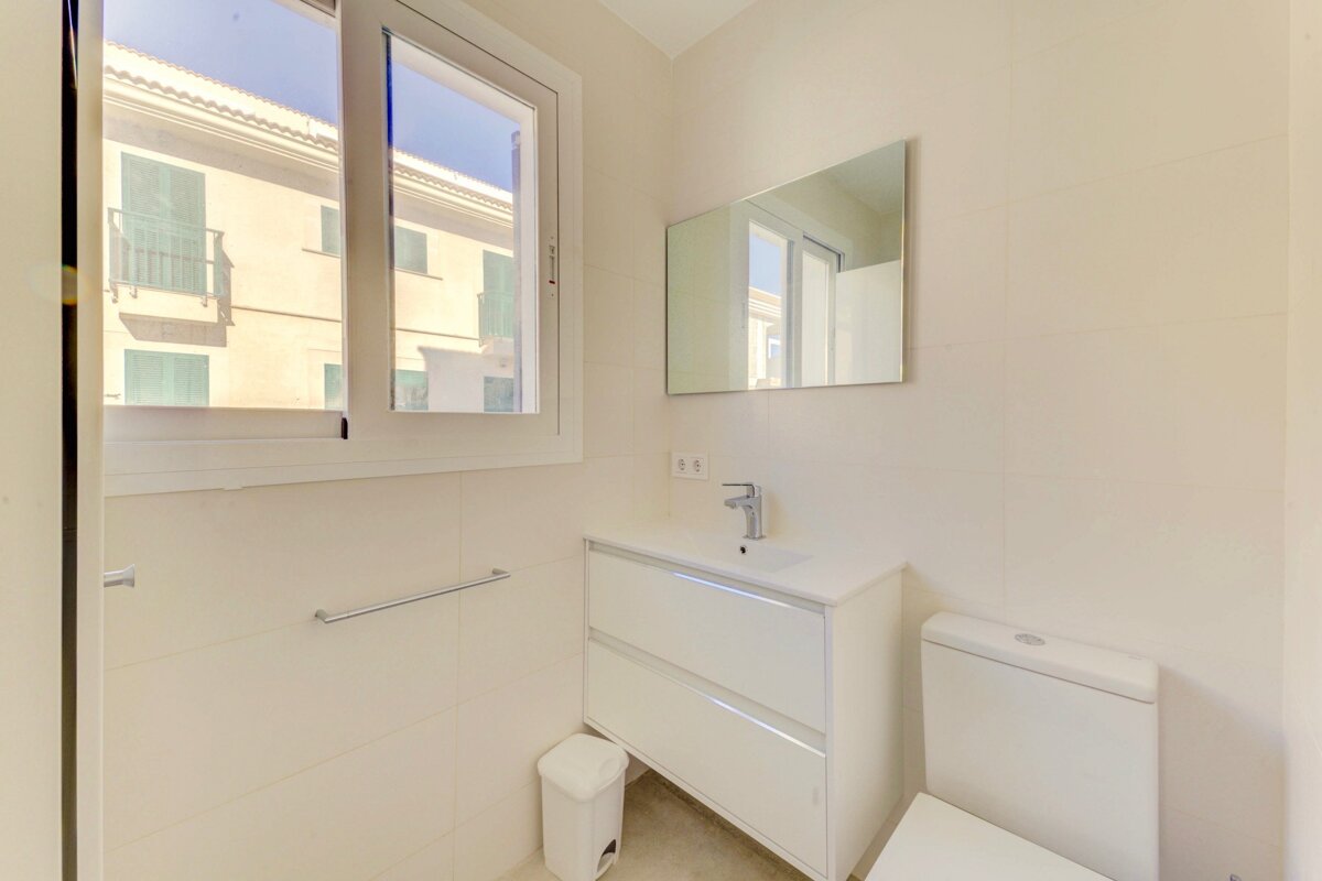 A bathroom with a toilet a sink and a mirror