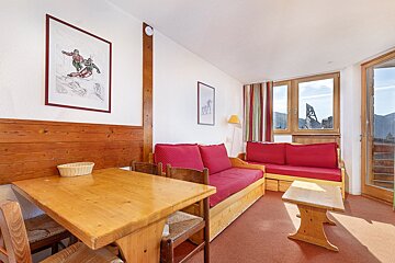 A living room with a couch a table and chairs