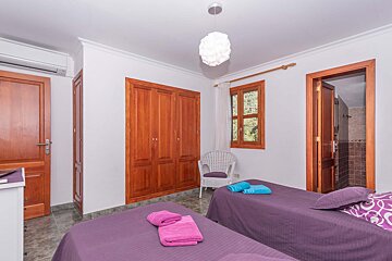 A bedroom with two twin beds and a chair
