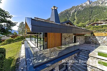 A mountain base real estate photo of a house with mountains in the background