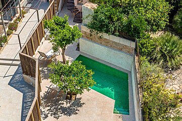 An aerial view of a swimming pool surrounded by trees