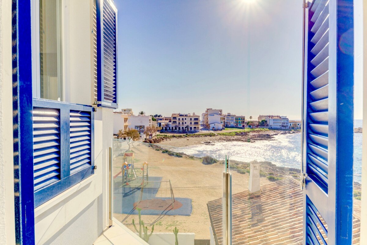 A view of the ocean from a balcony with blue shutters