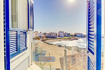 A view of the ocean from a balcony with blue shutters