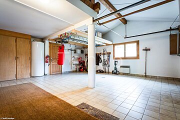 A boxing bag hangs from the ceiling of a garage