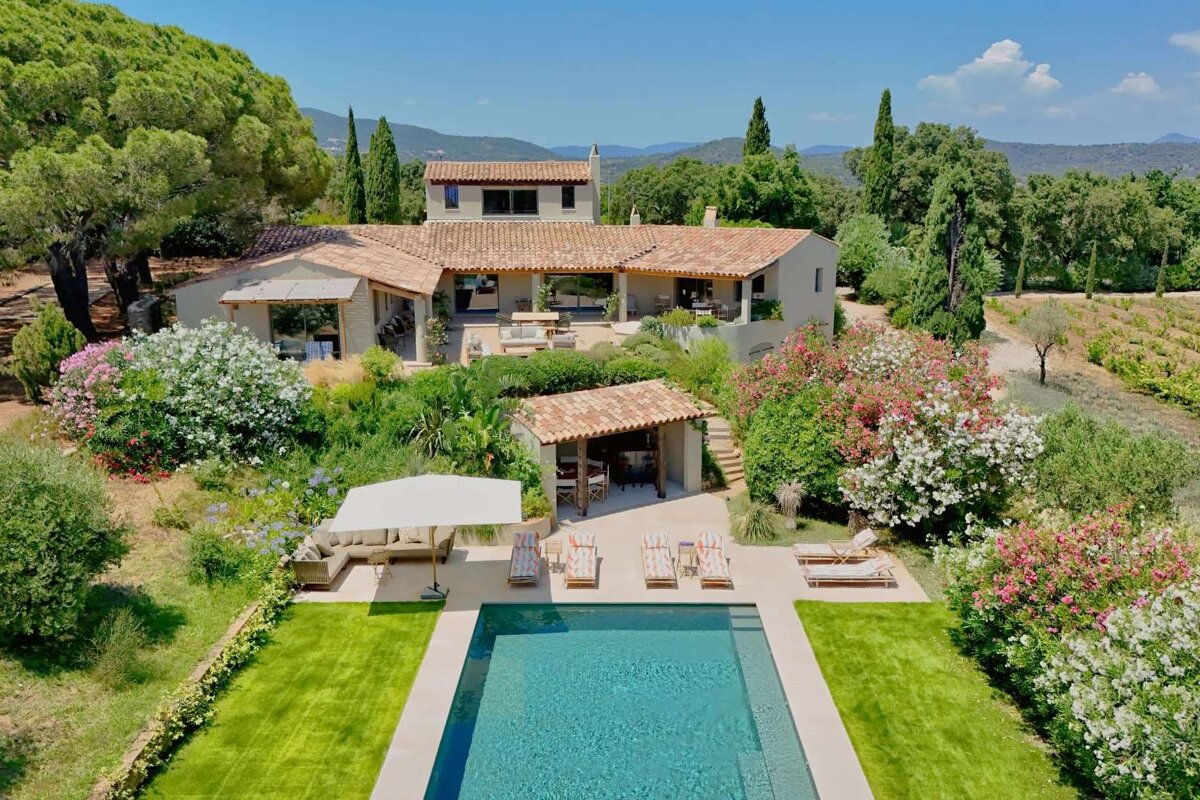 A large house with a swimming pool in front of it
