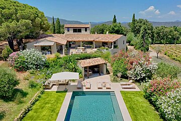 A large house with a swimming pool in front of it