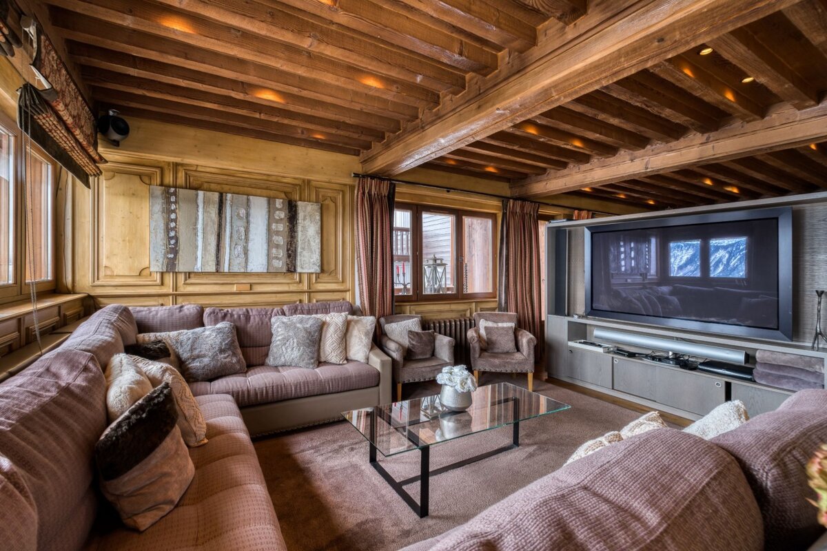 A living room with a large sectional couch and a flat screen tv