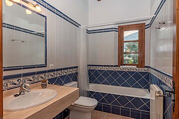 A bathroom with blue and white tiles and a sink