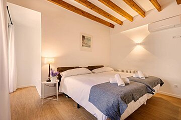 A bedroom with two beds and a picture on the wall
