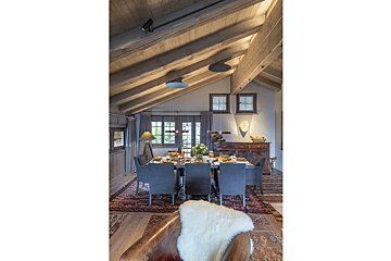 A dining room with a table and chairs and a rug