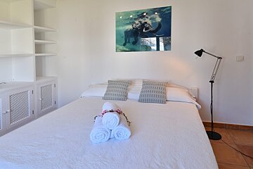 A bed with a picture of an elephant on the wall above it