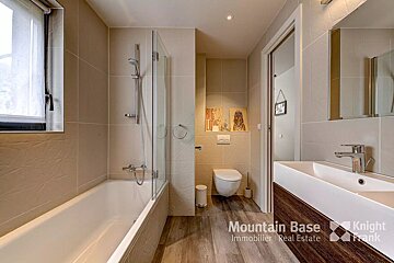 A bathroom with a sink and a toilet and the words mountain base on the bottom