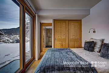 A bedroom with a bed and a sliding glass door that says mountain base