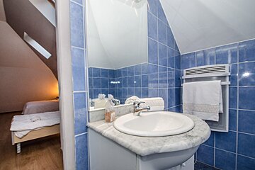 A bathroom with blue tiles and a white sink