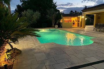 A large swimming pool is lit up at night