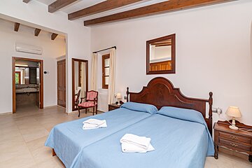 A bedroom with two beds and a mirror on the wall